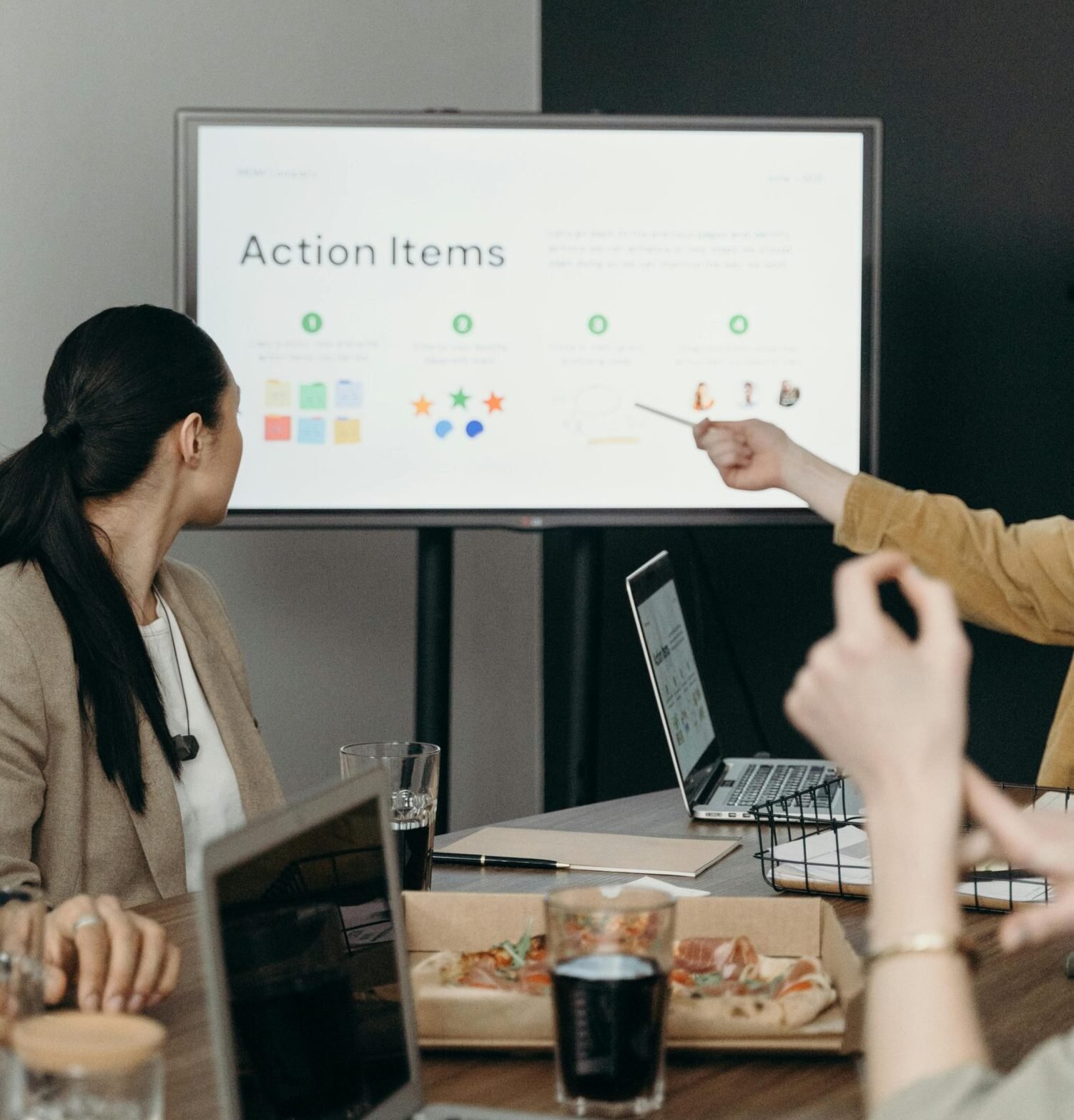Colleagues discussing a presentation of action items in an office setting.